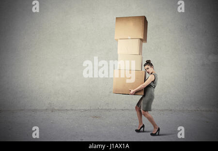 Brunette woman carrying heavy boxes Stock Photo