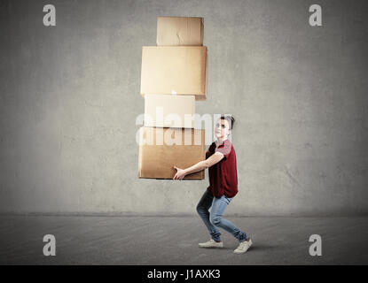 Woman carrying heavy boxes Stock Photo