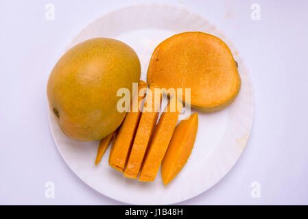 Mumbai / India  12 April 2017 Mango fruit ( cubes, slices) on the plate and butterfly isolated on white background Stock Photo
