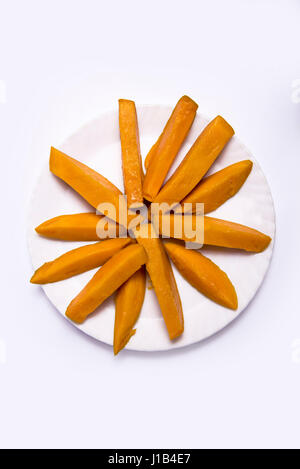 Mumbai / India  12 April 2017 Mango fruit ( cubes, slices) on the plate and butterfly isolated on white background Stock Photo