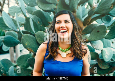 Smiling Mixed Race woman near cactus Stock Photo