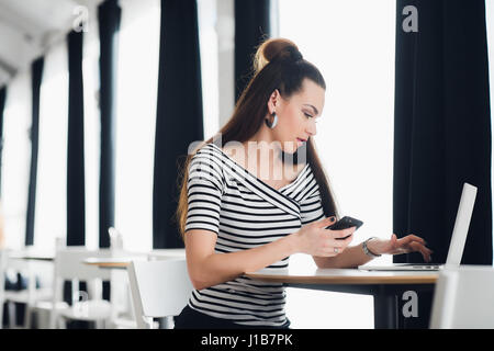 Administrative manager of restaurant business talking on phone with clients about banquet order and writing all details in notebook. Stock Photo