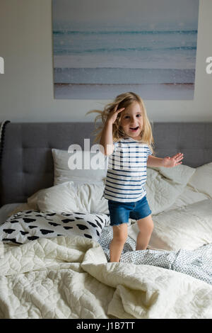 Caucasian girl jumping on bed Stock Photo