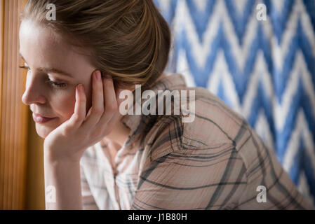 Pensive woman with hand on chin Stock Photo