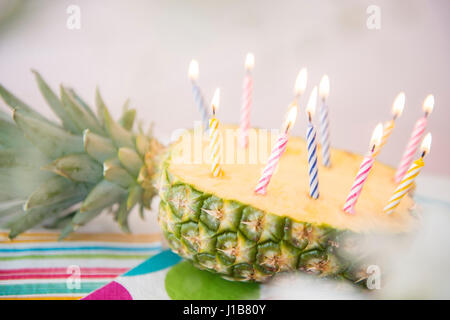 Candles burning in half of sliced pineapple Stock Photo
