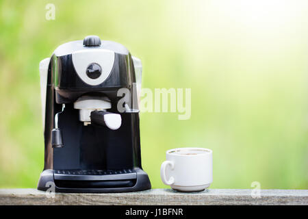 Coffee machine on wood table with cup of coffee and white background Stock Photo