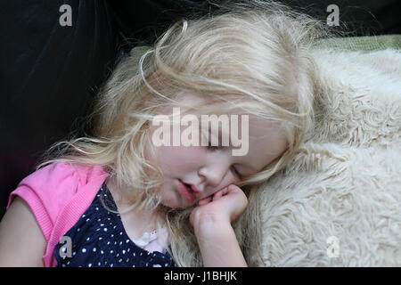 Little Three year old girl , child asleep on a furry pillow with her hand under her chin Stock Photo