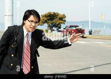 A businessman waiting and calling for a cab or taxi Stock Photo