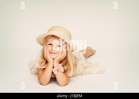 three year old girl, child lying on her tummy with hands around her face, little blonde girl, cuteness overload Stock Photo