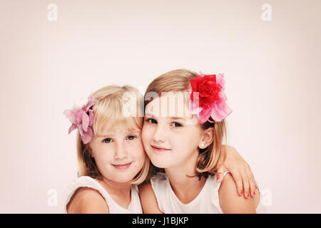 Portrait of three blonde girls sisters children smliing with with flowers in their hair best friends concept, besties, best friend concept Stock Photo
