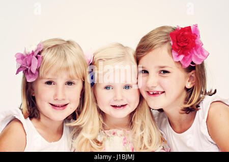 three blonde sisters portrait with flowers in their hair, together, best friends concept, best friend, besties Stock Photo