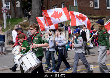 members of Scouts Canada holding Canadian flags march along Queen Street East in the Beaches Easter Parade 2017 Stock Photo
