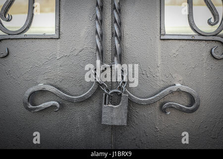 Old lock on a chain on an iron door Stock Photo