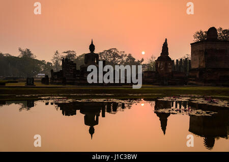 the Sukhothai histirical park in the morning light with silhouette scene,Sukhothai world heritage ancient temple in Thailand reflection with the water Stock Photo