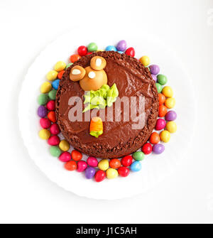 A decorated homemade chocolate Easter cake surrounded by mini Easter eggs. Stock Photo