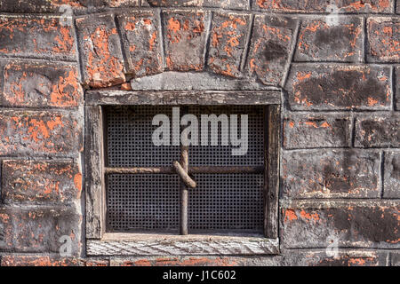 old window in the building with cross bars on the window to avoid unwelcome intrusion Stock Photo