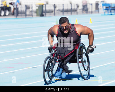 Middle Eastern man racing in wheelchair on track Stock Photo