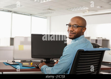 Smiling African American man using computer in office Stock Photo