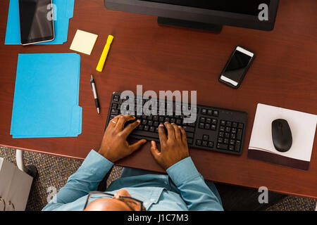 African American man typing on computer keyboard in office Stock Photo