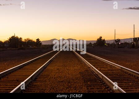 Railroad tracks in mountain landscape at sunset Stock Photo