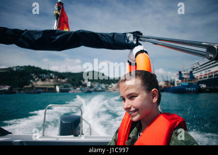 Caucasian woman wearing life-jacket in speedboat Stock Photo