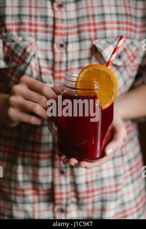 Woman holding glass of fruit tea with straw Stock Photo