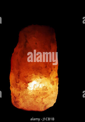 Himalayan salt rock lamp glowing on black background Stock Photo