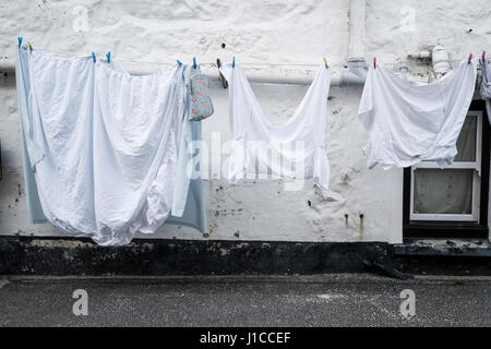 Washing out on a line against a white washed house in the traditional cornish coastal town of St Ives Stock Photo
