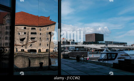 Distorted reflection of old Noma restaurant building in new Krøyers Plads development with Inderhavnen bridge and Royal Danish Playhouse in background Stock Photo