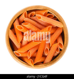 Red lentils penne pasta in wooden bowl. Uncooked dried glutenfree noodles. Lens culinaris. Short-cut medium length tubes with ridges cut diagonally. Stock Photo