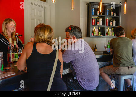 People enjoying a wine tasting at the colorful and modern tasting room at Kaena Wine bar in Los Olivos, CA in the heart of the Santa Ynez Wine Country Stock Photo