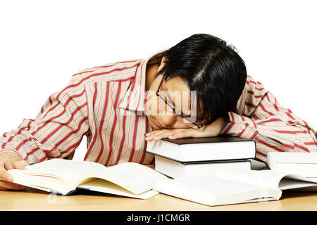 An isolated shot of a young man falling asleep while reading books Stock Photo