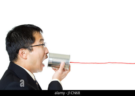 An isolated shot of a businessman communicating with a tin can phone Stock Photo