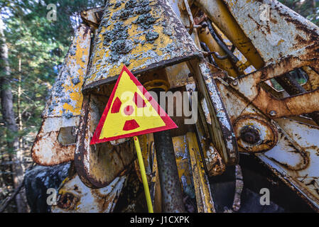 Warning sign in front of irradiated scrap bucket in Pripyat city of Chernobyl Nuclear Power Plant Zone of Alienation around the nuclear reactor disast Stock Photo