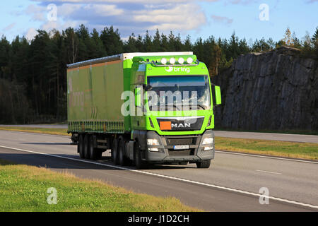 PAIMIO, FINLAND - SEPTEMBER 30, 2016: Lime green MAN TGX 28.520 cargo truck flashes bright high beams briefly when moves along motorway in South of Fi Stock Photo