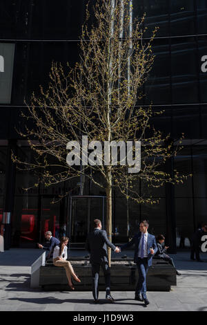 Two associates shake hands after meeting beneath a spring tree on Lime Street in the City of London, the capital's financial district Stock Photo