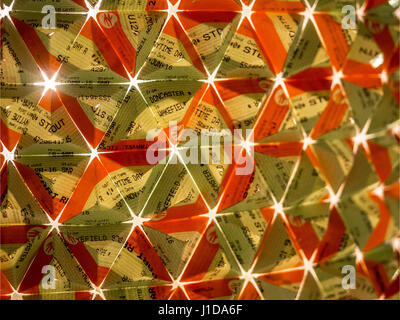 Close up of train tickets folded into triangular pattern with light shining through from behind Stock Photo