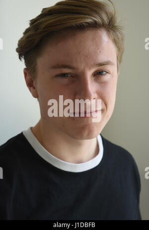 A portrait of a nineteen year old teen boy on a black background ...