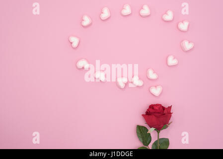 Red rose with marshmallow bubble speech hearts on pink paper background minimal style Stock Photo