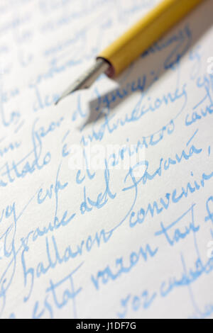 Handwritten correspondence in Spanish language (italics typeface) on paper with blue ink and ancient nib pen on background Stock Photo