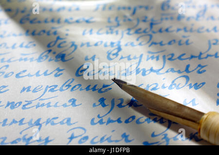 Handwritten text in cyrillic script (Russian language, old orthography before 1918) on paper with blue ink and quill pen tip Stock Photo