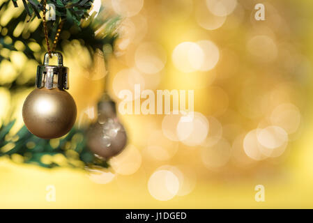 Golden christmas ball ornament decoration on fir tree over gold circle bokeh blur background with copy space for text, greeting card new year Stock Photo