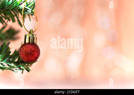 Christmas ball ornament decoration on fir twig over pink circle bokeh blur background with copy space for text, greeting card new year Stock Photo