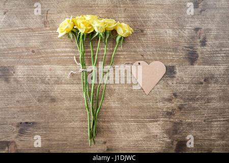 Bunch of yellow roses with heart shaped tag Stock Photo