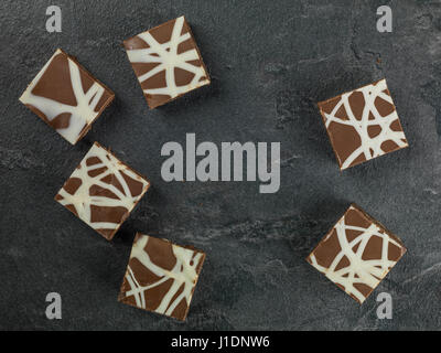 Individual Decorated and Iced Chocolate Tiffin Cakes Against a Black Background Stock Photo