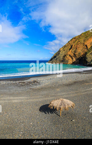 Umbrella on pebble beach Playa de Vallehermoso on La Gomera island, Spain Stock Photo