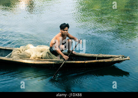 A fisherman paddles his boat out to sea in a small fishing village. Lăng Cô (Lang Co), Vietnam, southeast Asia Stock Photo