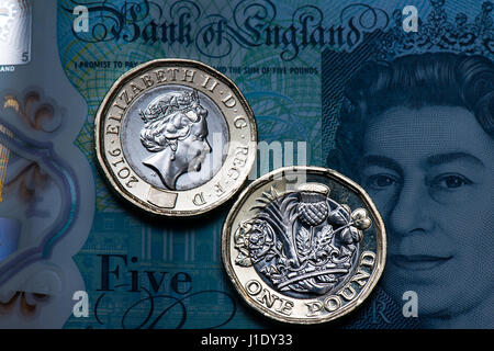 New one pound coins on a new £5 note. The new 12-sided coin entered circulation on March 28 2017 and the new £5 polymer note on 13 September 2016. Stock Photo
