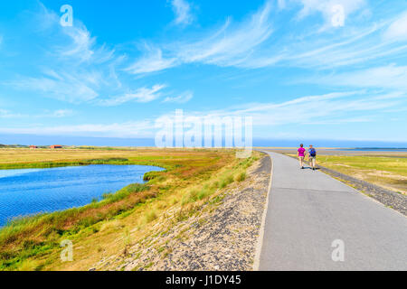 Couple of tourists walking on footpath in countryside landscape of Sylt island near List village, Germany Stock Photo