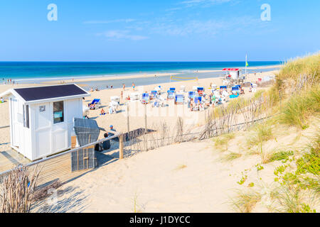 RANTUM BEACH, SYLT ISLAND - SEP 8, 2016: view of white sand beach with people sunbathing in wicker chairs on southern coast of Sylt island, Germany. Stock Photo